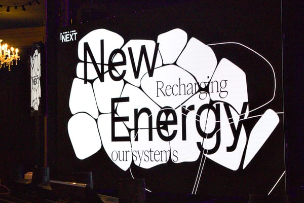 A video screen showing a logo saying New Energy: recharging our systems