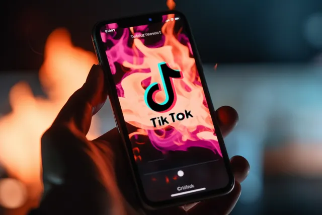 The TikTok logo on fire on an abstract smartphone