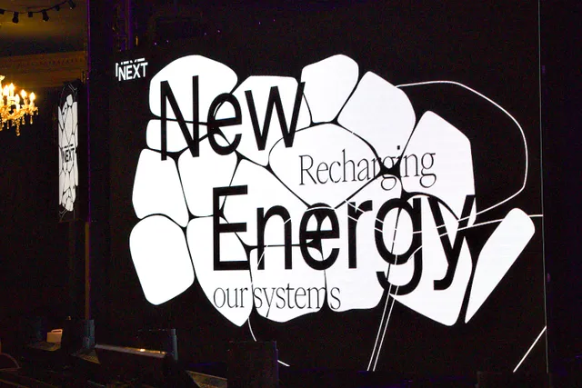 A video screen showing a logo saying New Energy: recharging our systems